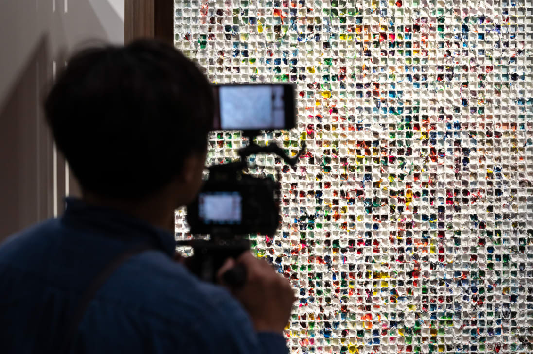 A visitor capturing a work by Yunizar, presented by Gajah Gallery in the Kabinett sector at Art Basel Hong Kong 2024. 