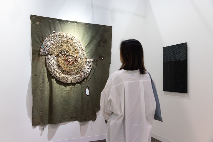 A visitor in Smac Art Gallery's booth at Art Basel Hong Kong 2024. 