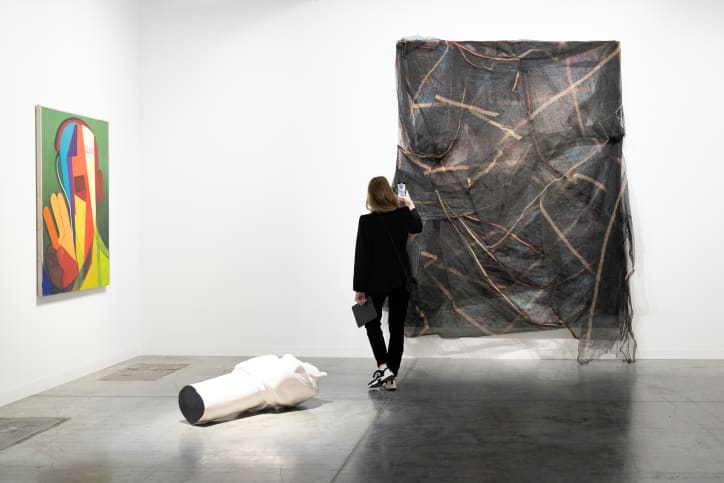 A visitor looking at Untitled, 2014, by David Hammons, on Hauser & Wirth’s booth at Art Basel Miami Beach 2024.