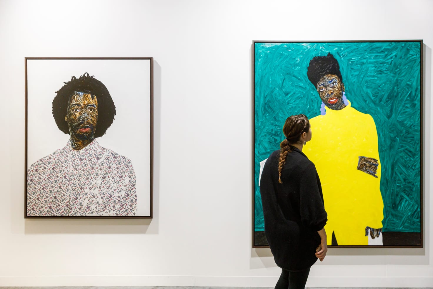 A visitor in front of works by Amoako Boafo, presented by Mariane Ibrahim Gallery at Art Basel Miami Beach 2019.