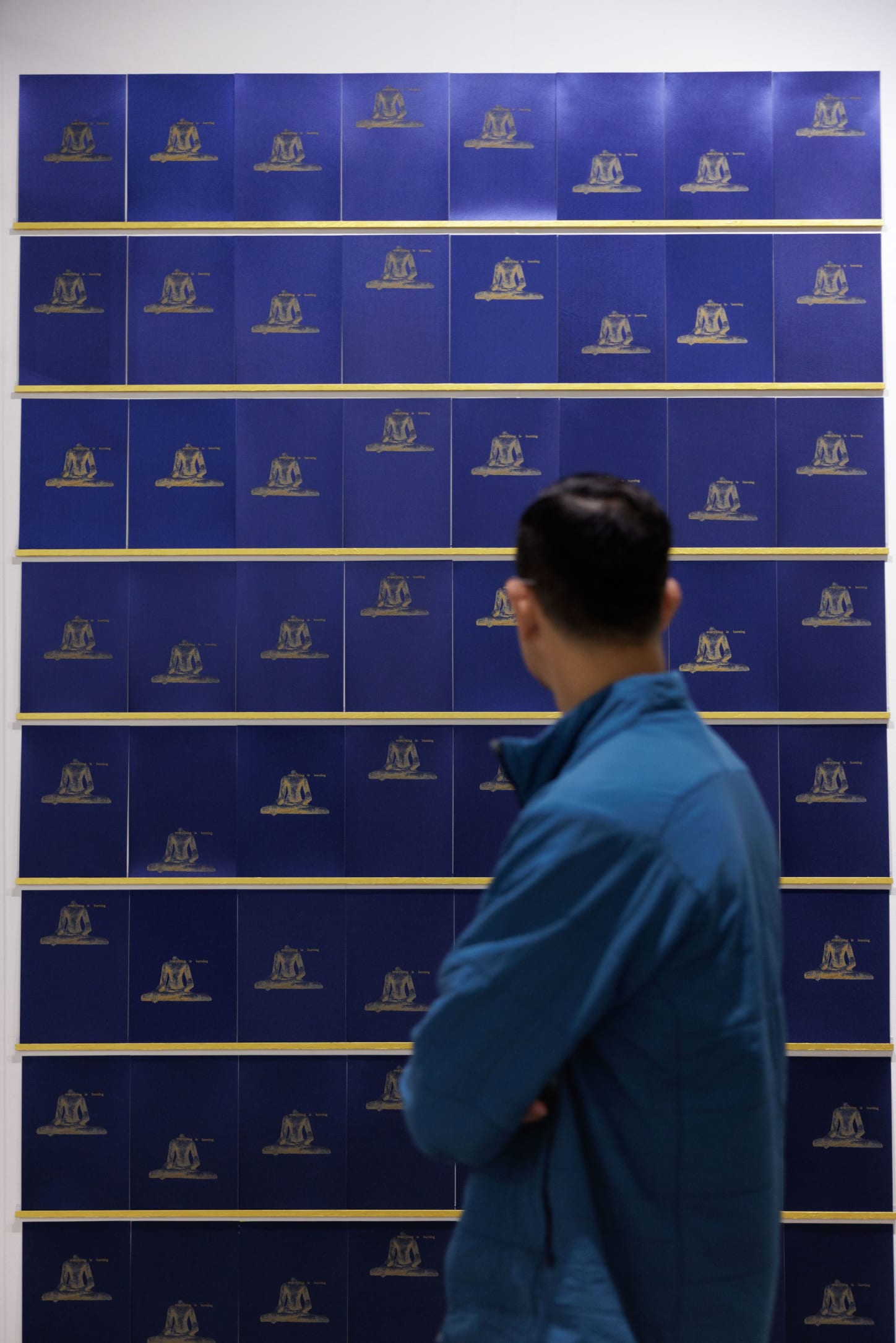 A visitor in front of a work by Raqs Media Collective, presented at Art Basel Hong Kong 2025 by Hanart TZ.