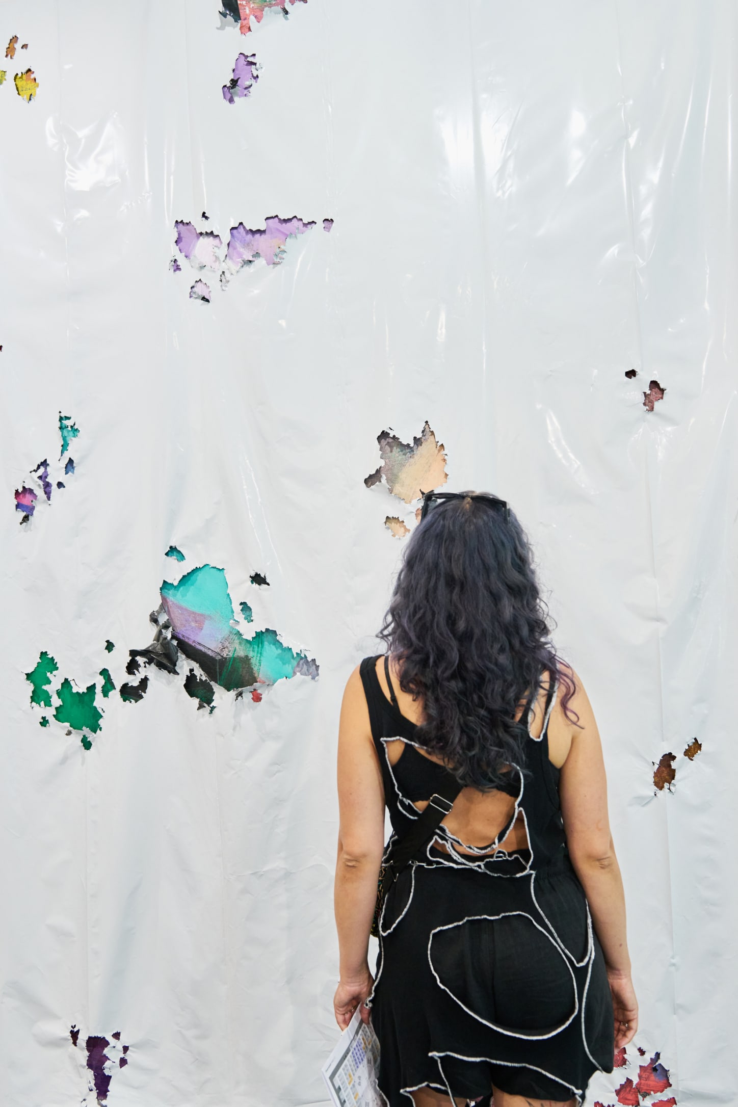 A visitor in front of a work by David Hammons, presented at Art Basel in Basel 2025 by Thomas Dane Gallery.