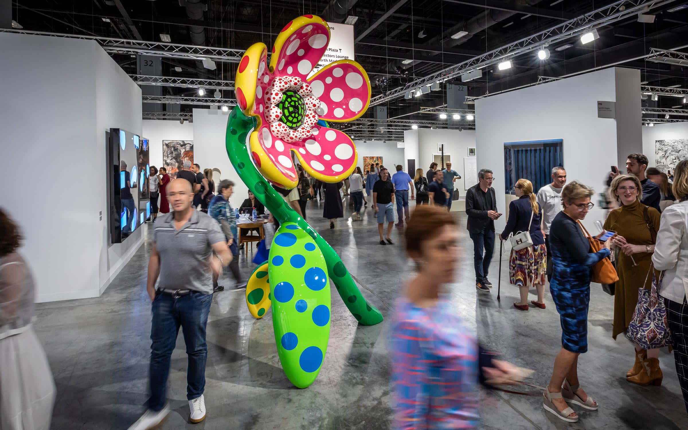 Visitors discover Art Basel's 2019 Miami Beach edition, walking by a large Yayoi Kusama sculpture on view at Victoria Miro (H7)