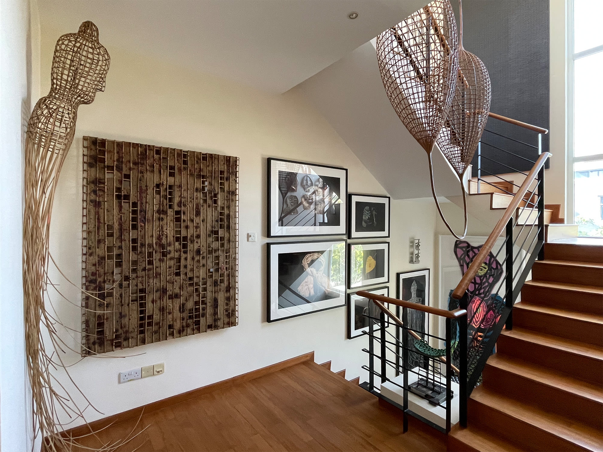 The stairway in Jim Amberson's home, with works by Sopheap Pich and Hak Kim. 