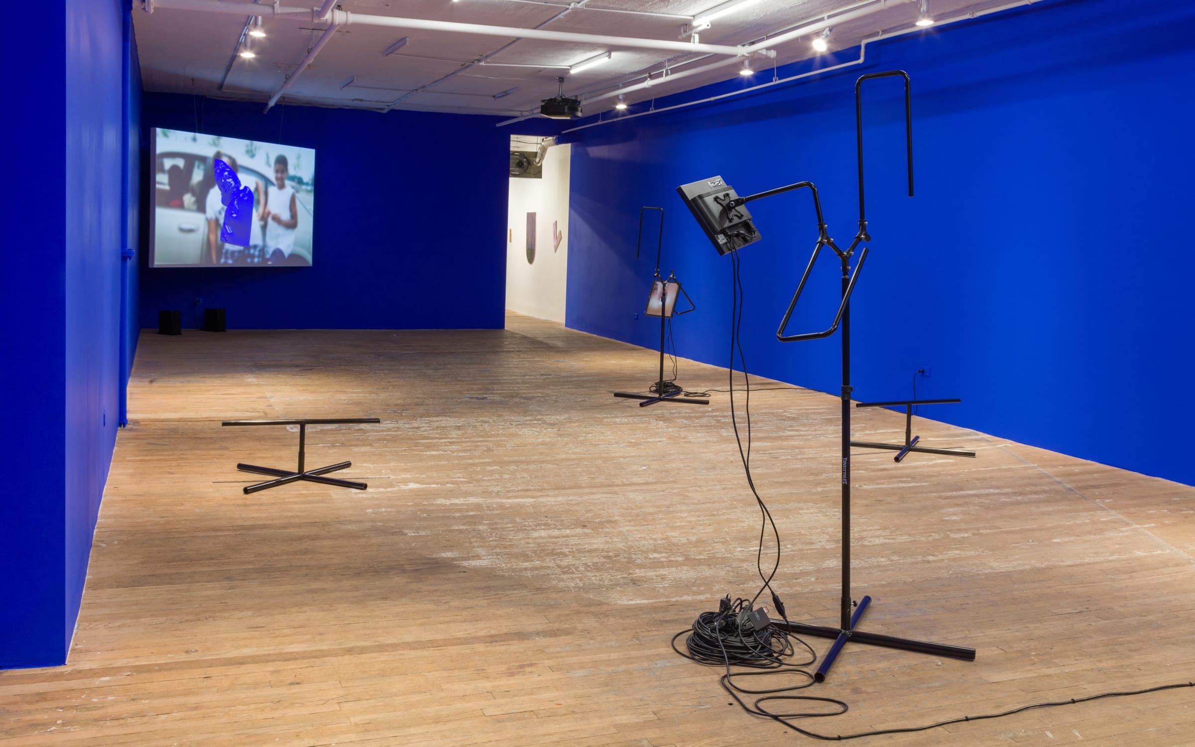 View of Sondra Perry's video installation IT’S IN THE GAME ‘17 or Mirror Gag for Vitrine and Projection, 2017, a video installation with color and sound, presented at Bridget Donahue gallery in a room painted Rosco Chroma Key Blue. Commissioned by the Henie Onstad Kunstsenter, Oslo (HOK) and the Institute of Contemporary Art (ICA), University of Pennsylvania. Images © Sondra Perry, courtesy of the artist and Bridget Donahue, New York City.