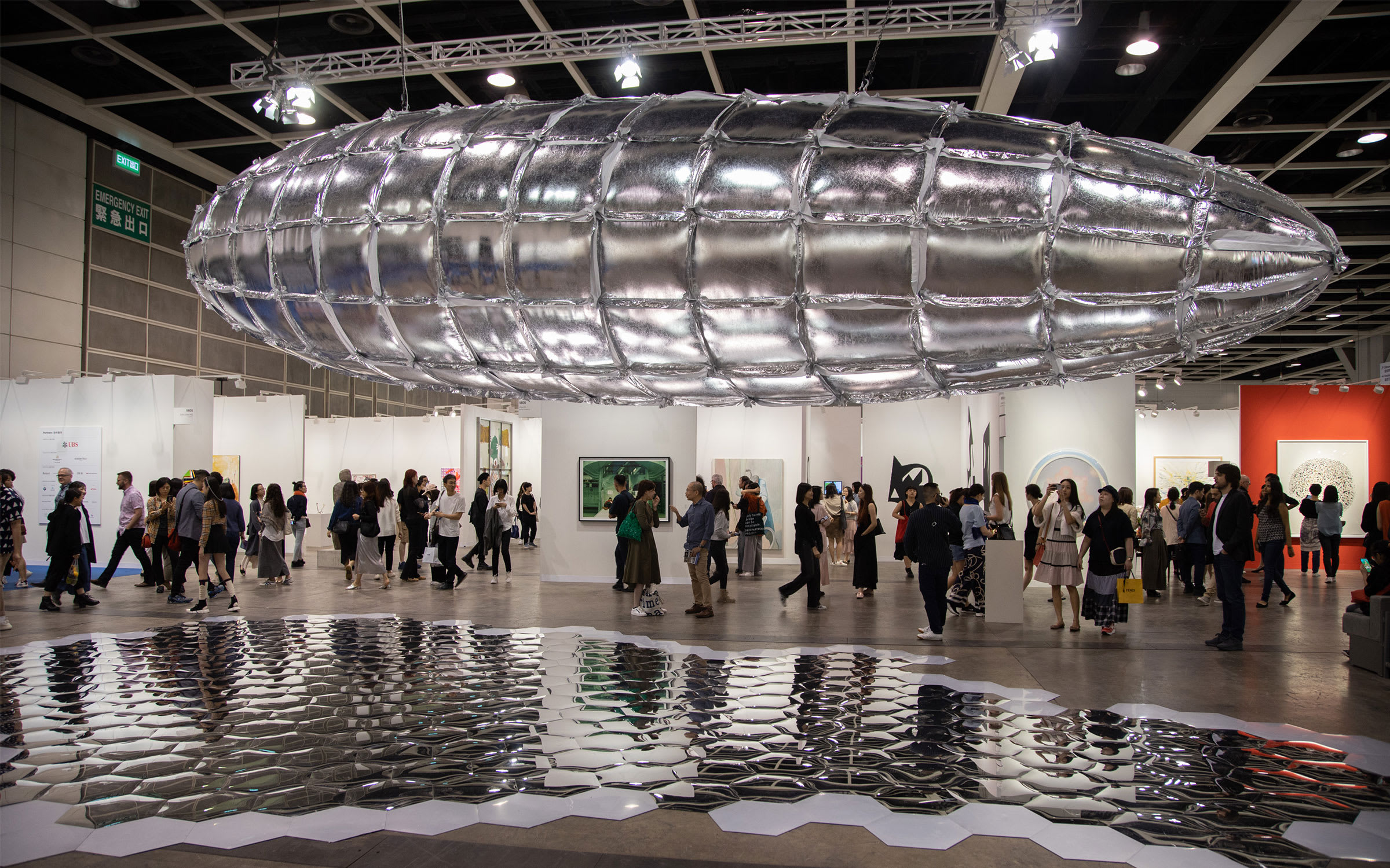 Lee Bul's sculpture Willing To Be Vulnerable – Metalized Balloon, floating above the show's visitors.