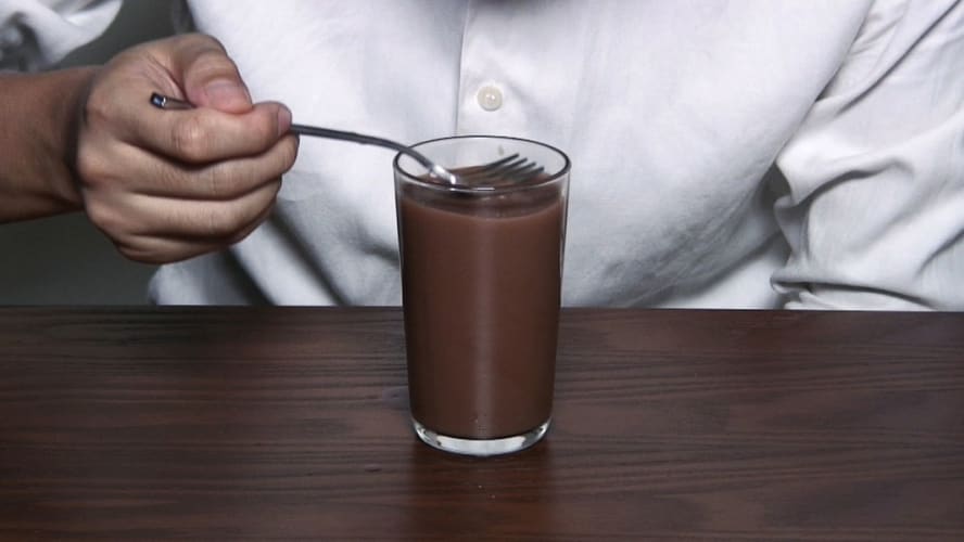 Drinking a glass of hot chocolate with a fork