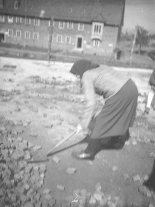 A German woman is cleaning leftovers of where her house was before it was destroyed by bombs. Kassel, 1947