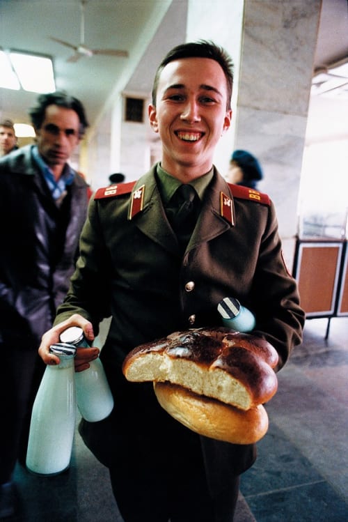 A Soviet soldier beams with pleasure at finding staple food at a state store, where low prices often meant short supplies.